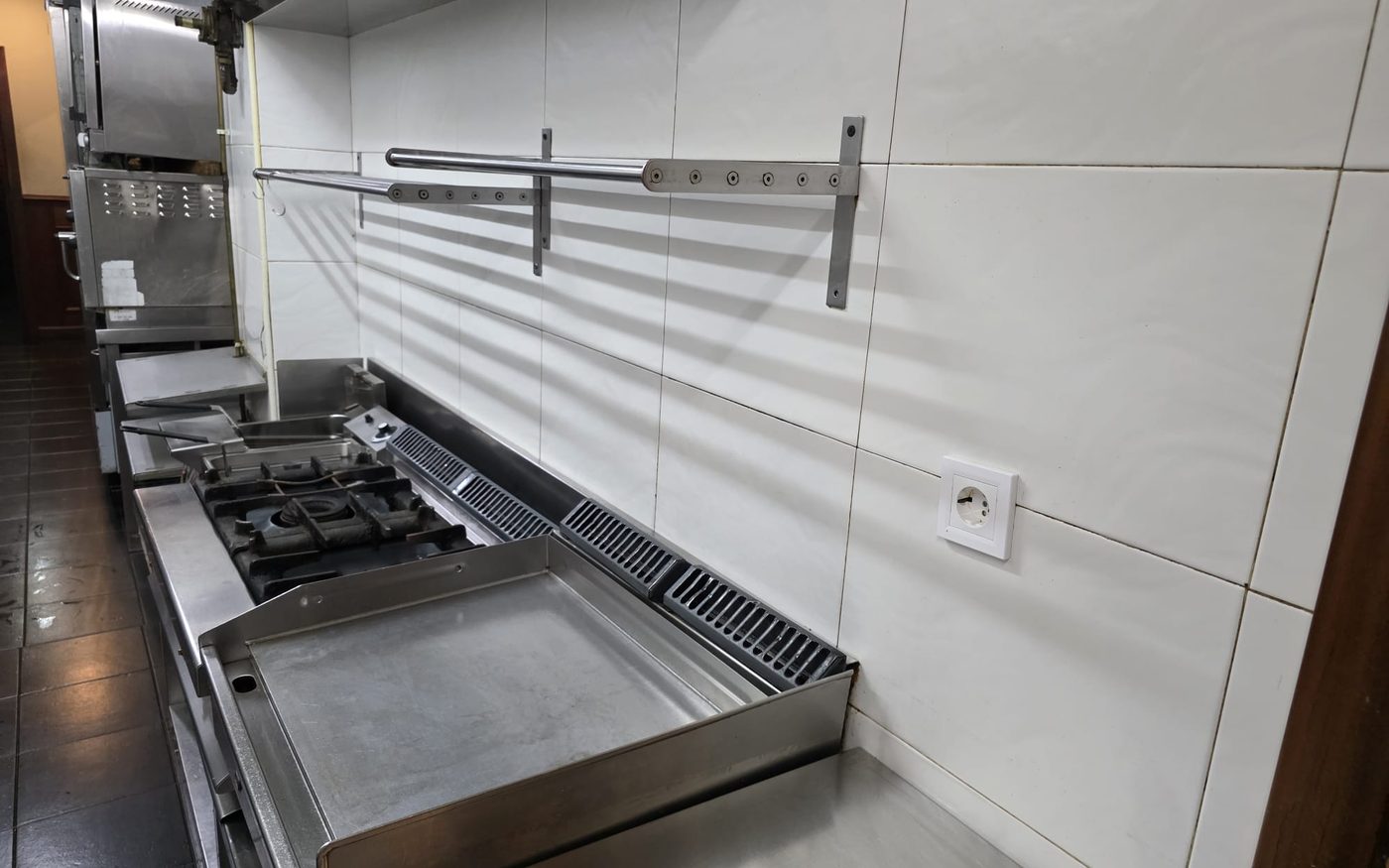 Fogones, plancha y azulejos de una cocina industrial limpios tras la intervención de Bilbo Limpieza